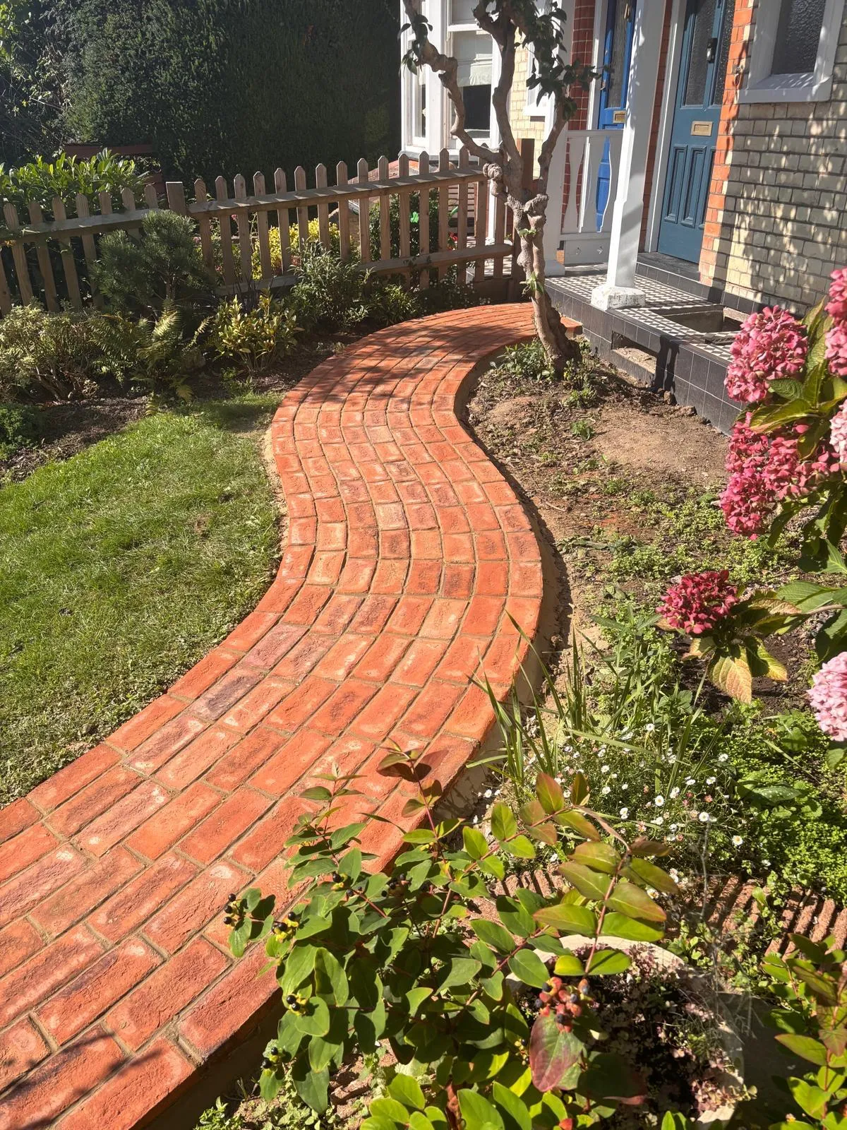 A brick path in front of a house.