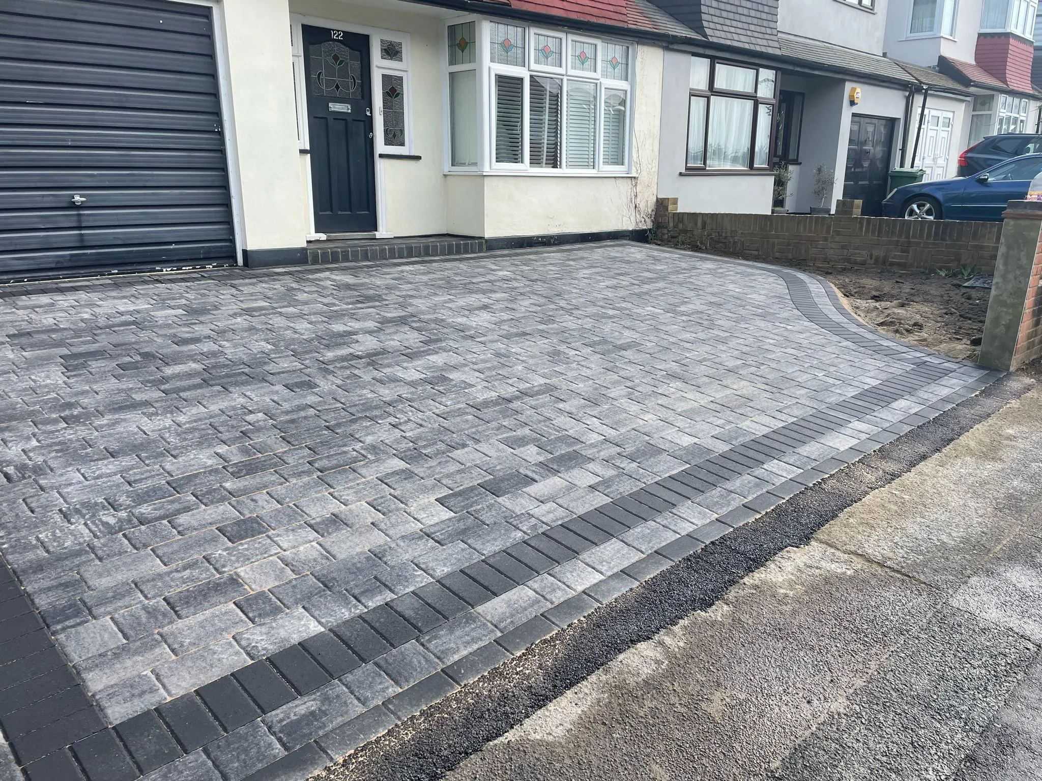 A house with a large brick driveway in front of it.