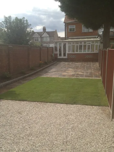 a backyard with a brick fence and grass