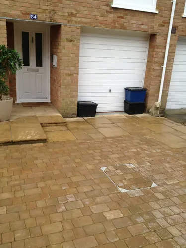 a brick patio with a potted plant in front of it