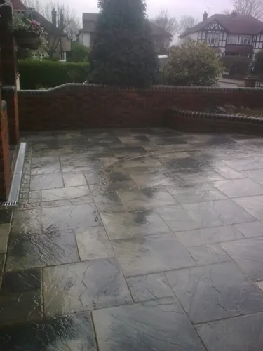 a patio with a brick wall and a wooden fence