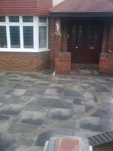 a brick house with a large patio and steps leading to the front door
