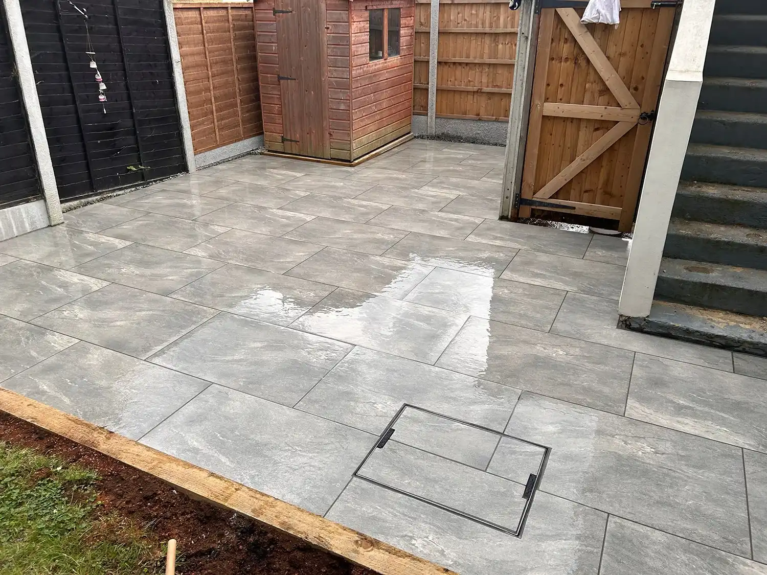 A backyard area with a wooden fence and steps.