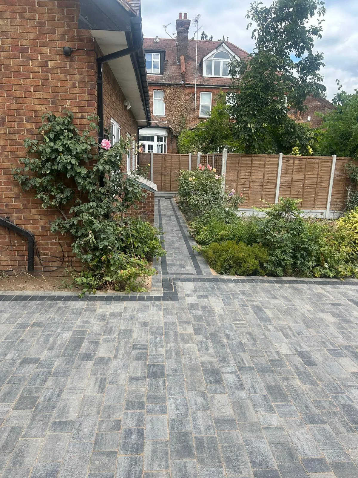 A brick walkway leading to a brick house.