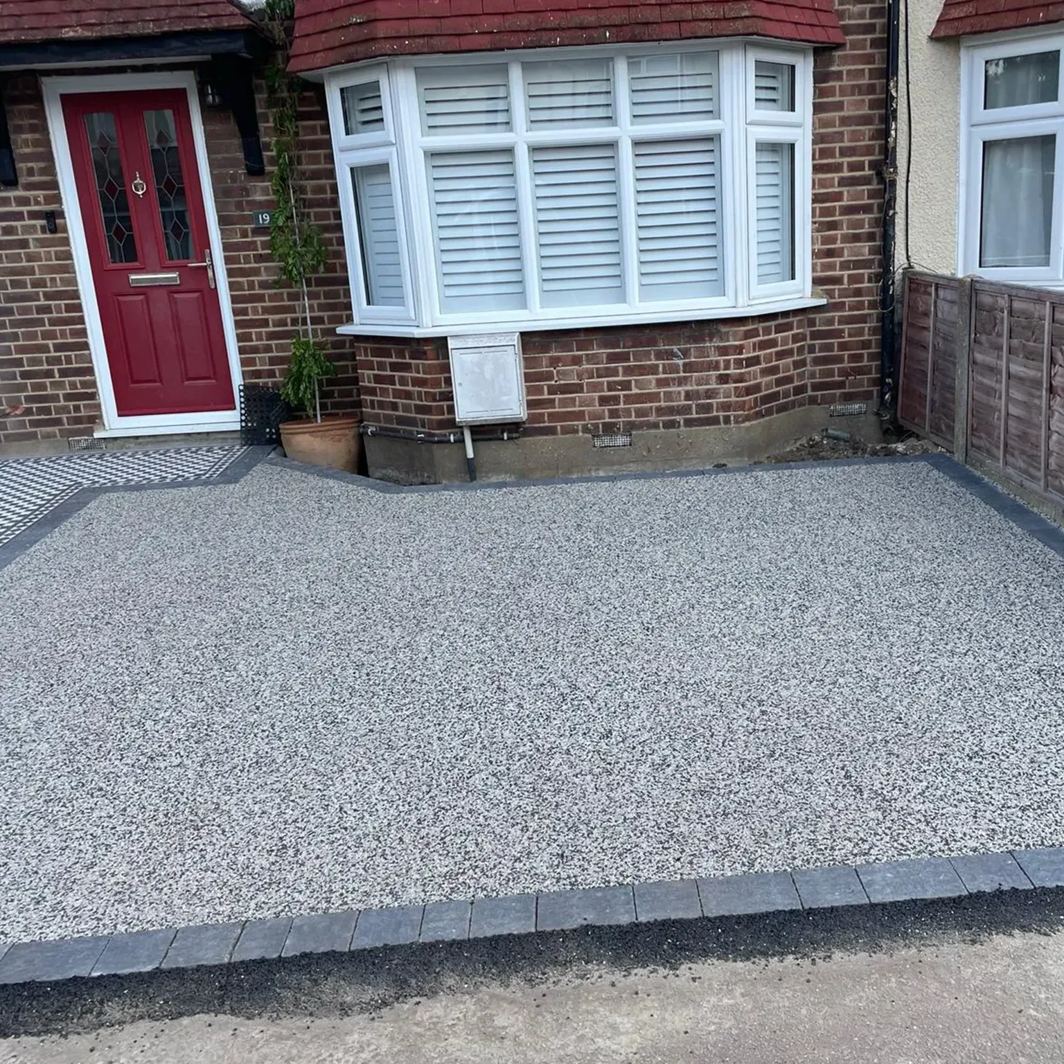 a house with a red door and a brick driveway