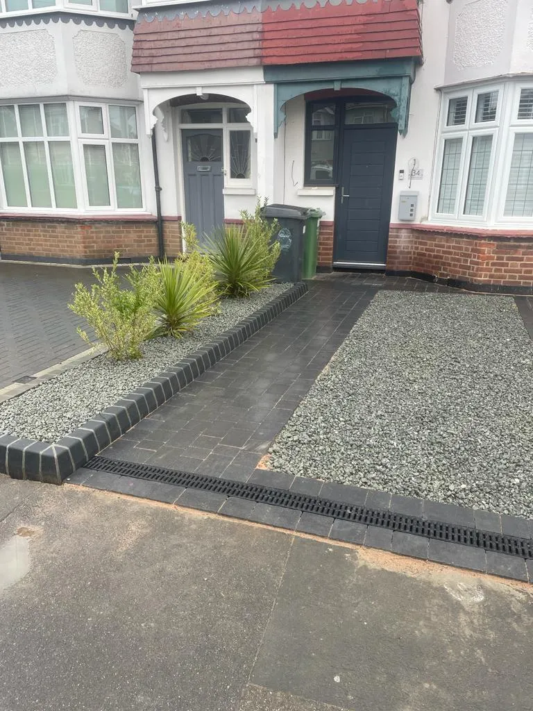 a house with a driveway and landscaping in front of it
